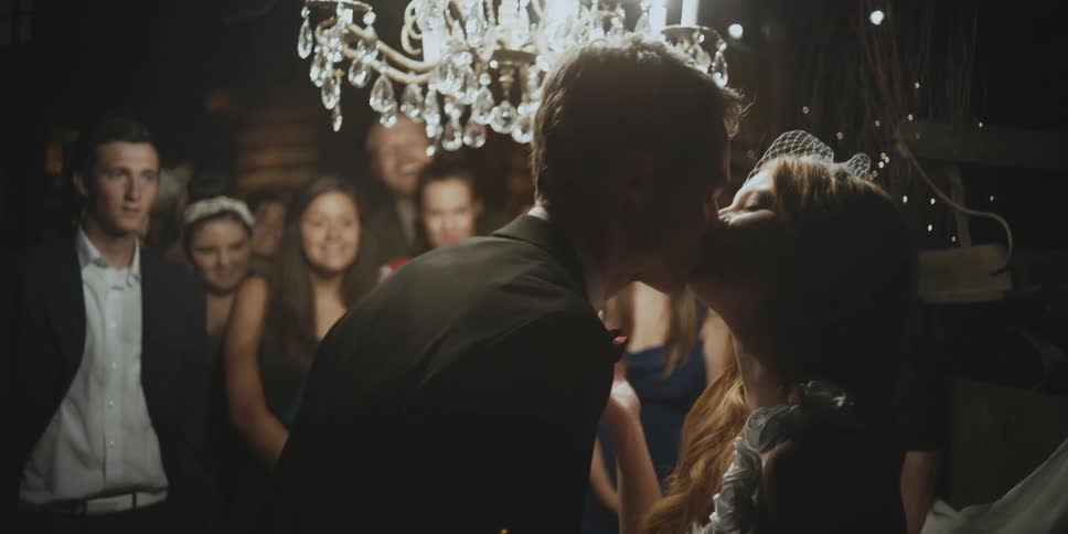 A girl and boy kiss at a party