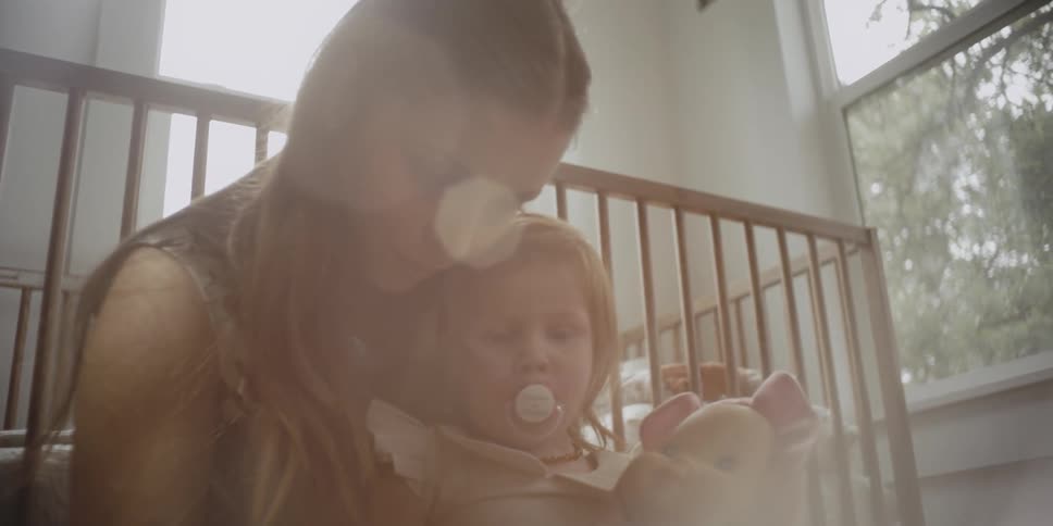 Woman holds a child holding a toy