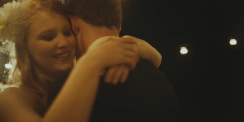 A bride and groom dance at an outdoor wedding reception