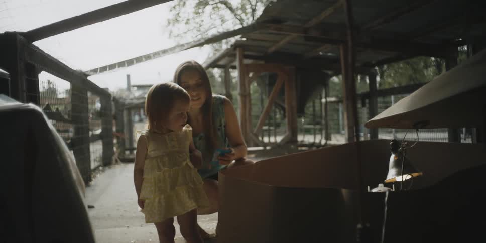 A baby girl walks in an enclosure for animals