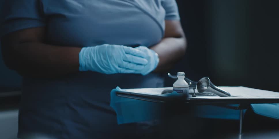 A medical worker fills a syringe with liquid medicine