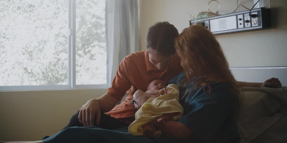 Parents hold their newborn baby
