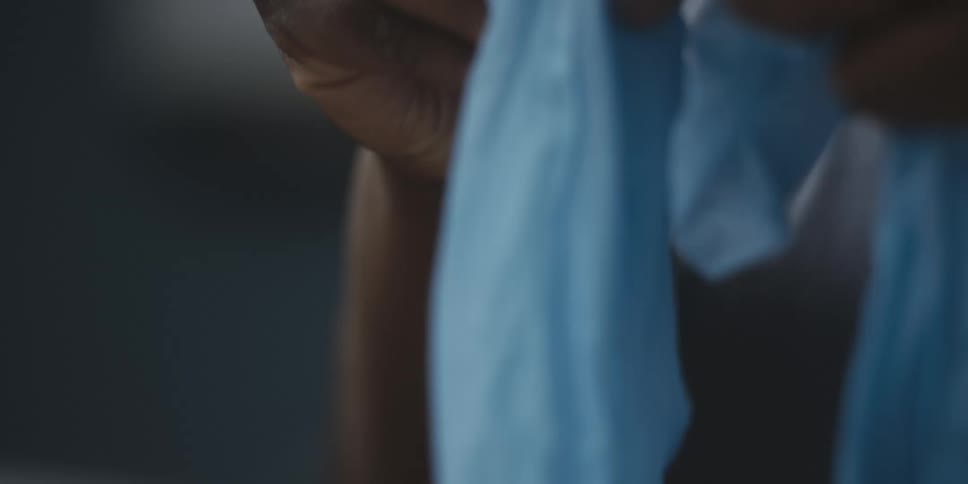 A man opens up and puts on latex gloves