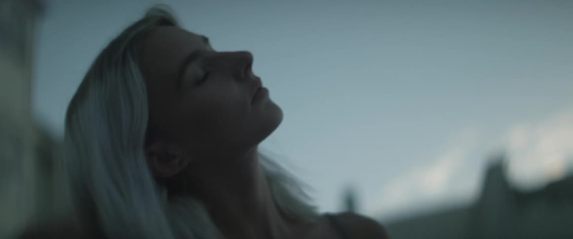 Blonde woman stretching outside at dusk