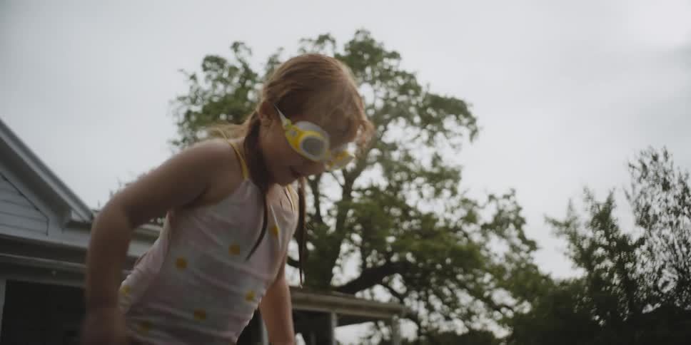 A child puts on her goggles and dives