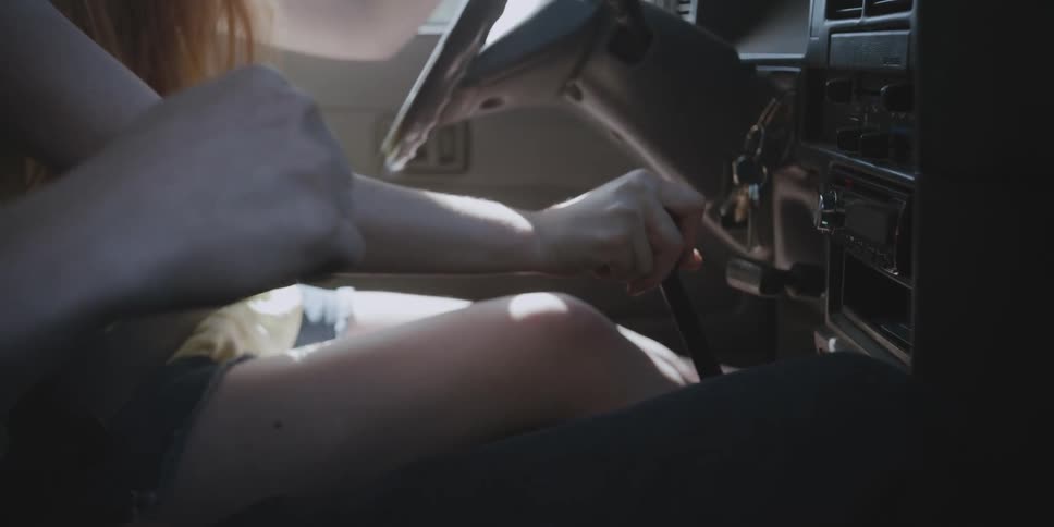 A girl is learning how to drive stick