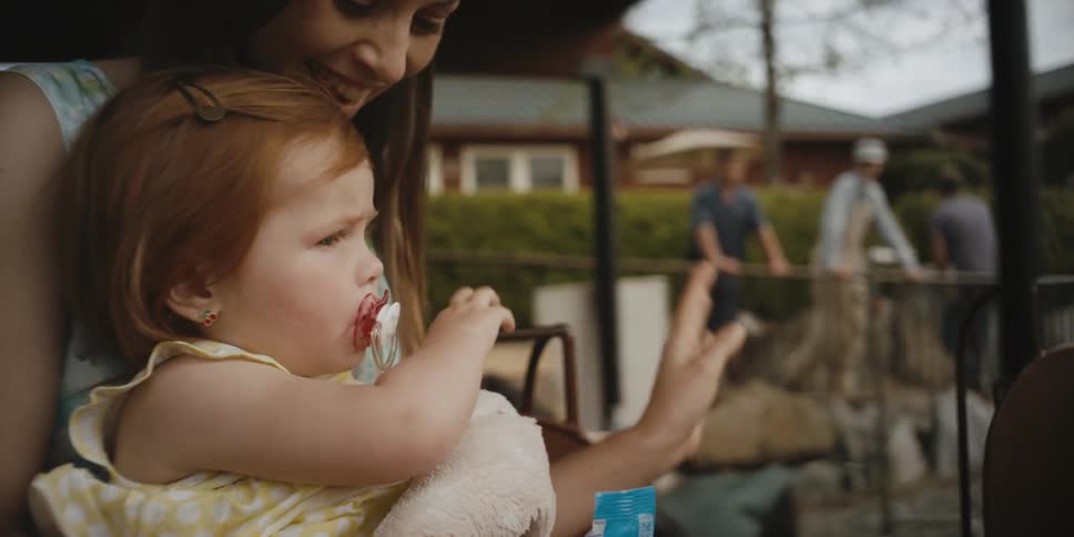 A little girl waves at people she passes