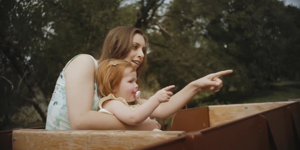 A woman is holding her child as they take a ride