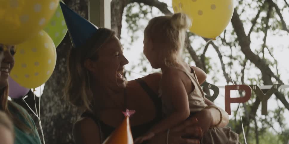 A woman and girl laugh at a birthday party