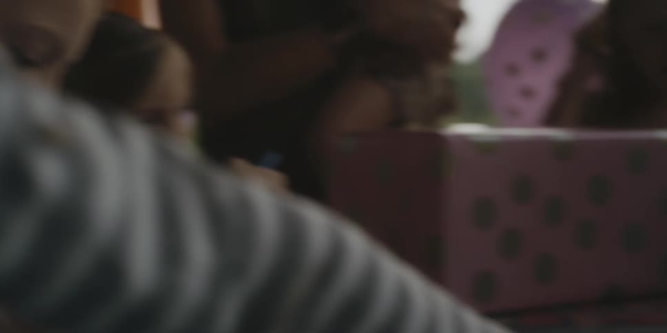 A woman and young girls celebrate at a birthday party