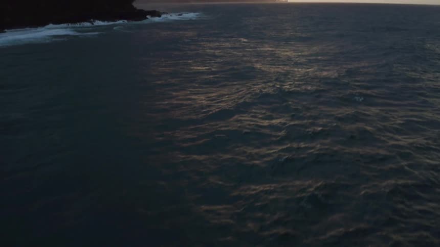 A body of water at sunset on a cloudy day