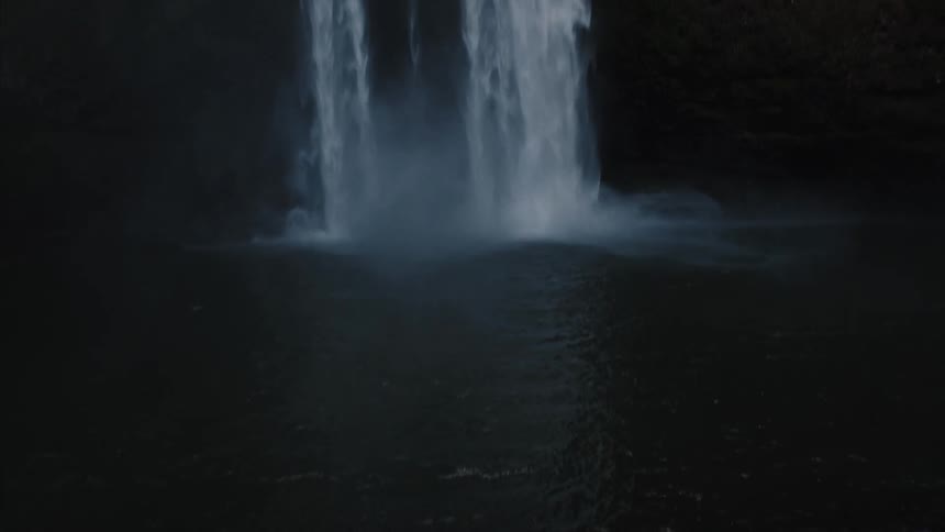 Panning view from the bottom to the top of a high waterfall