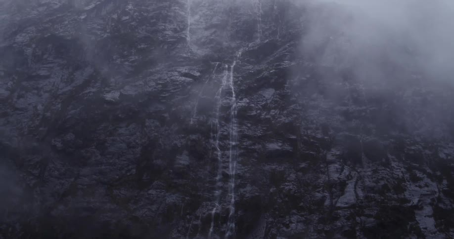 Streams of water running down a large rock crag
