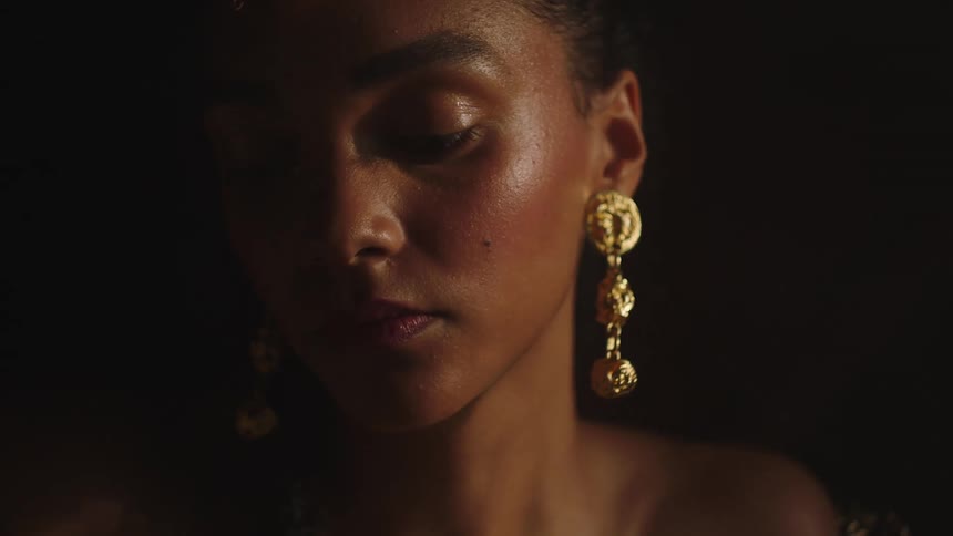 The face of a beautiful woman wearing a large dangling gold earring