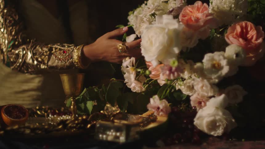 A woman is touching a bouquet of flowers