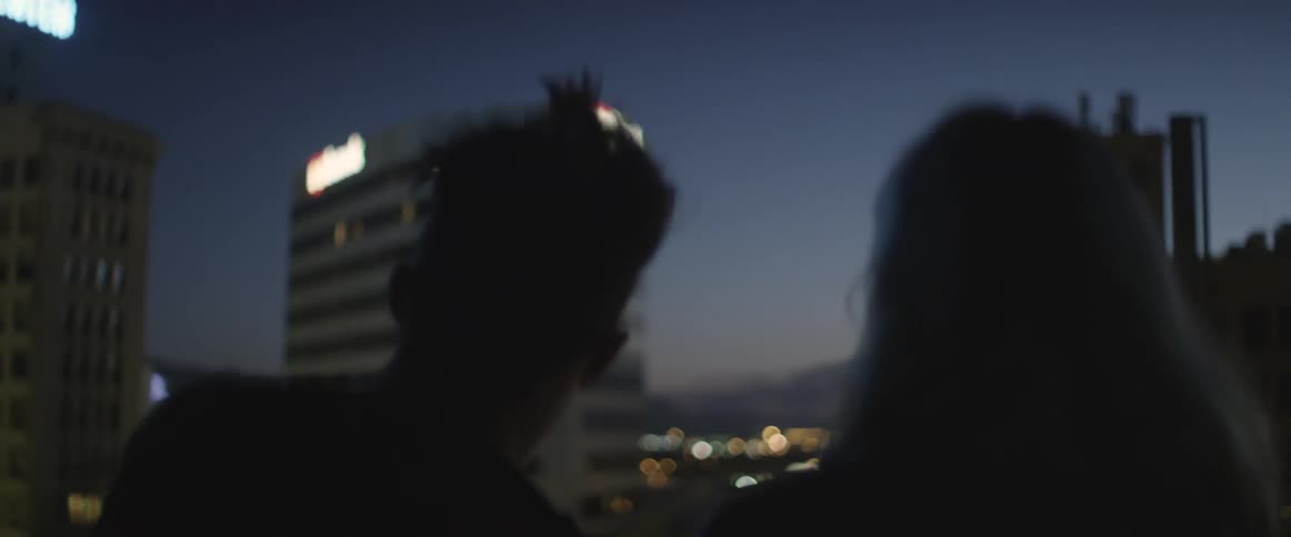 Couple looking at a tall building from a balcony