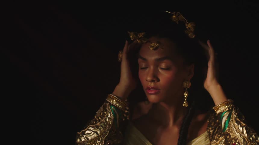 Eclectic woman looks to her left and her right as she touches the crown on her head