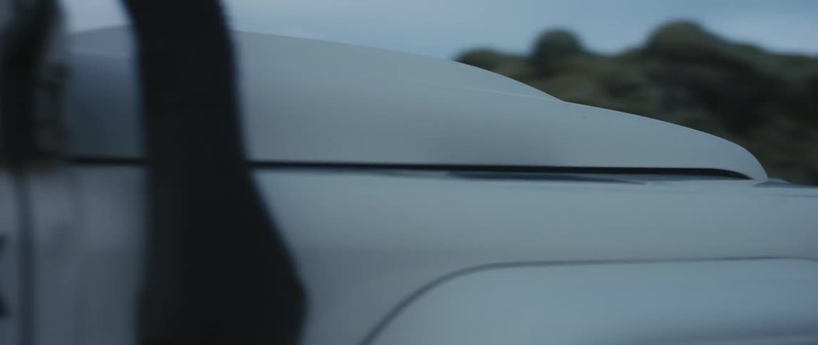 A vehicle slowly travels offroad on a cloudy day