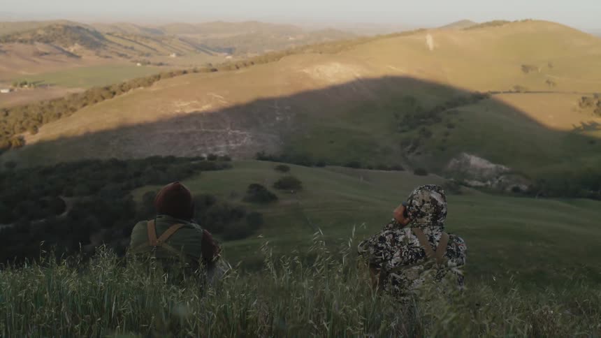 Two people sit on the hill together