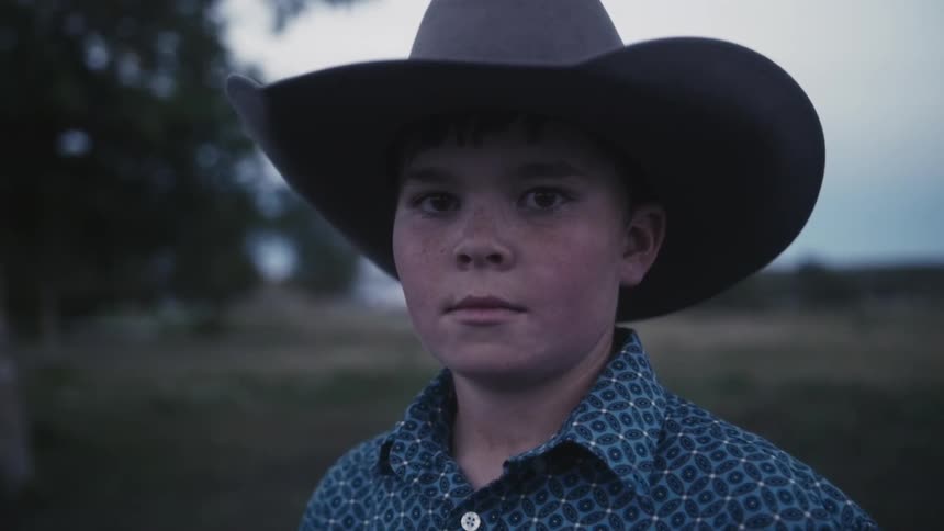 Young cowboy looks into the camera lens