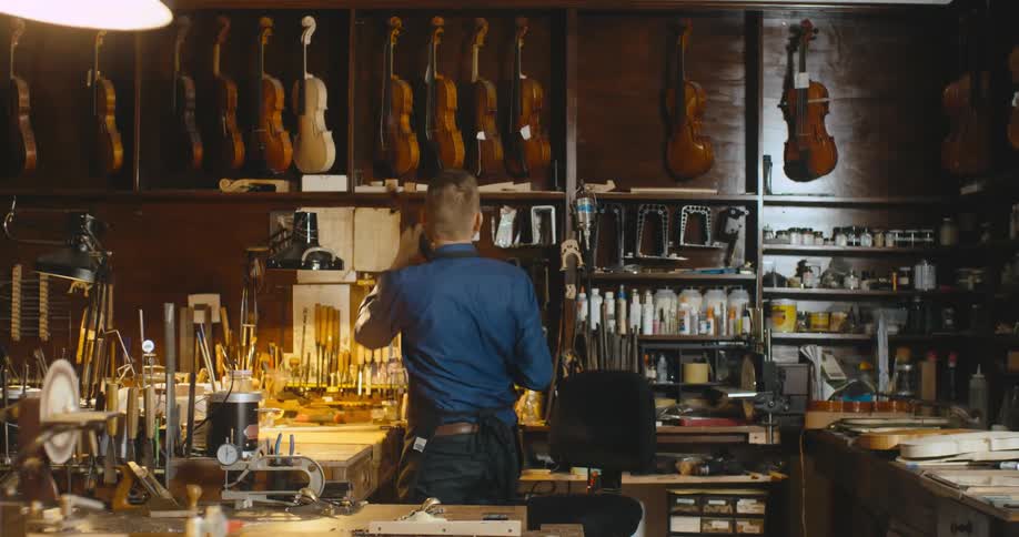 A man is working in a music store with instruments