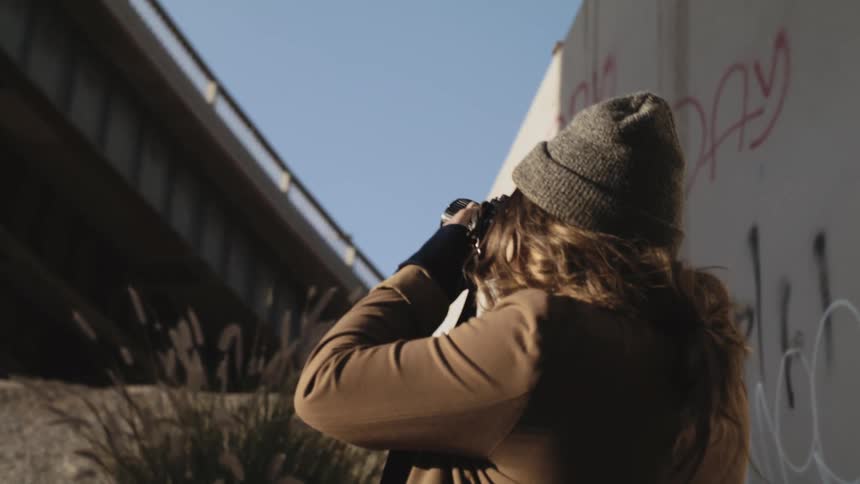 A woman is taking pictures of an overpass