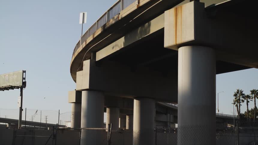 Traffic travels along and below an overpass during the day