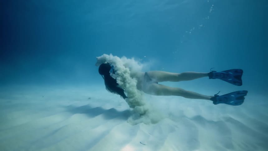 A woman is swimming under the ocean sea