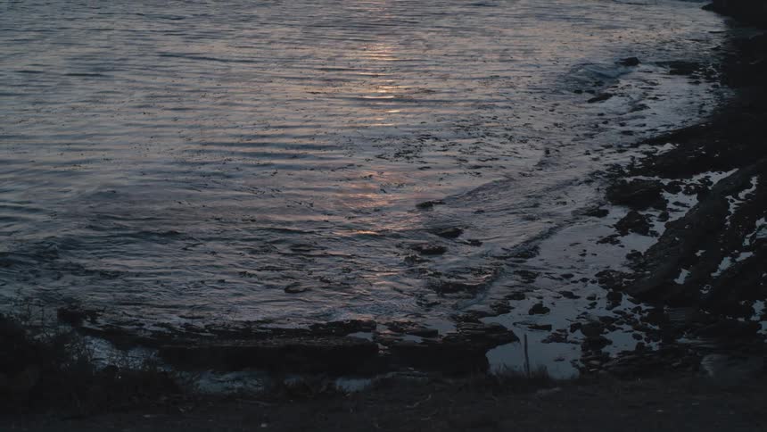 Aerial view of ocean water waves at dusk