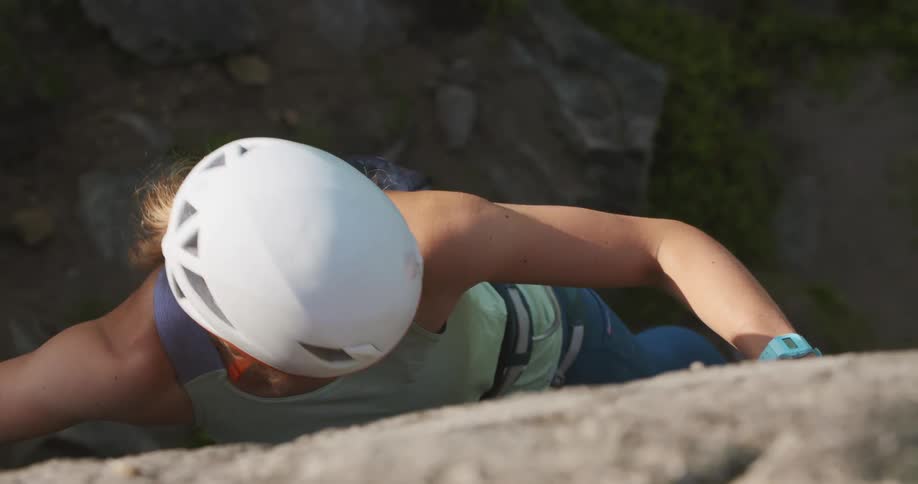 A woman is rock climbing up a mountain in spring
