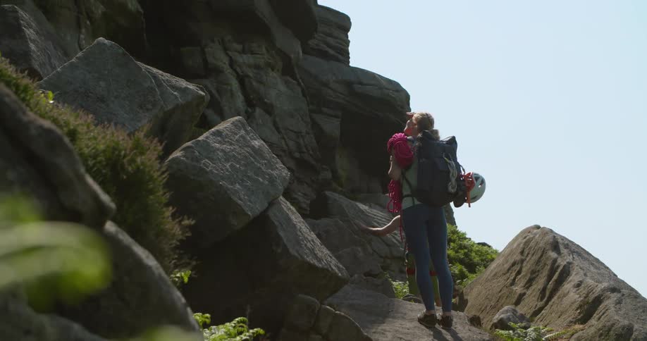 Man and woman are rock climbing up a mountain in spring
