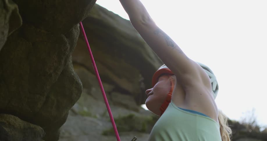 A woman is climbing up the cliff