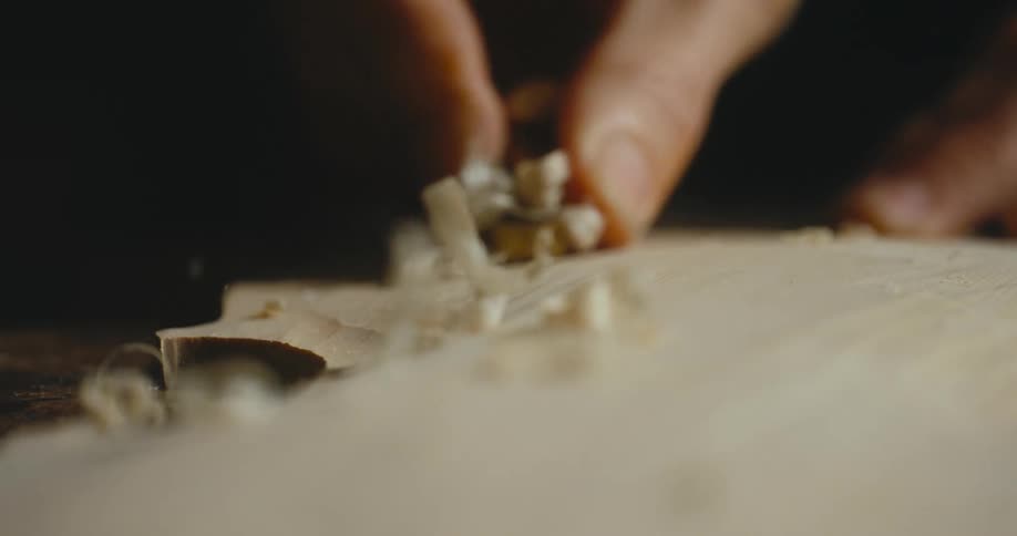 A person sanding a piece of wood