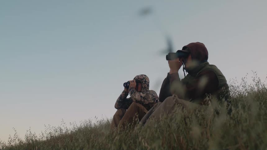 Two people looking through binoculars
