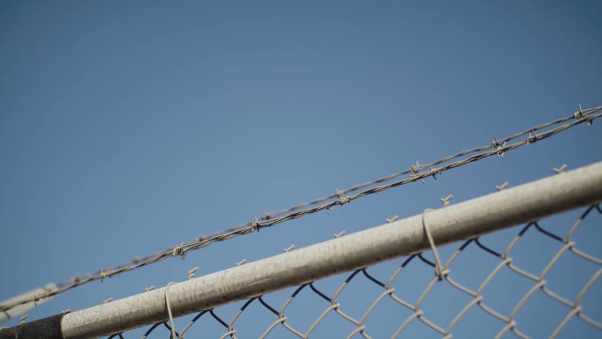 Close up view of a fence with barb wire is displayed