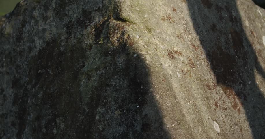 Two hikers give off a shadow on a large rock