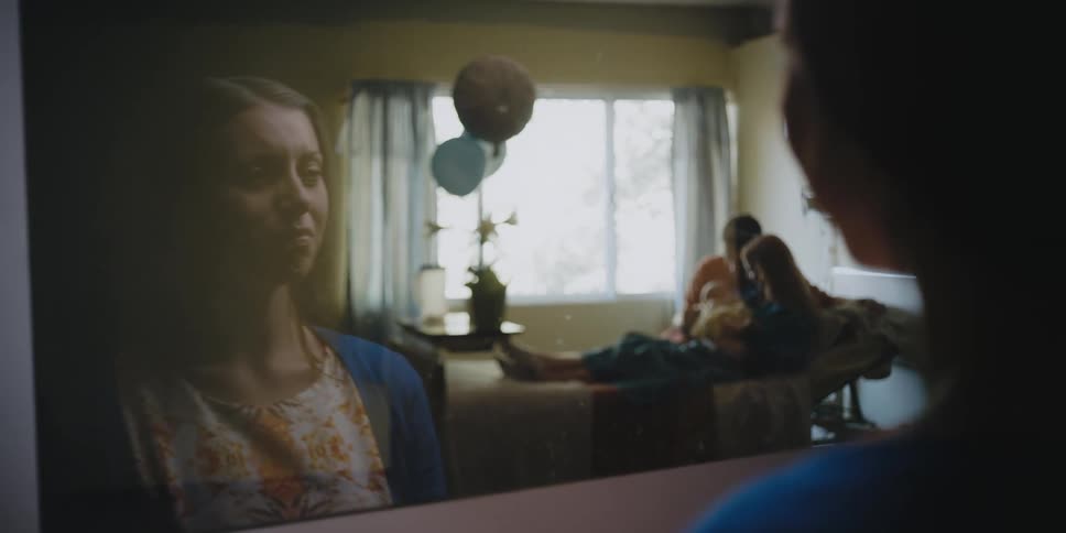 A woman cries while looking at new parents with their baby