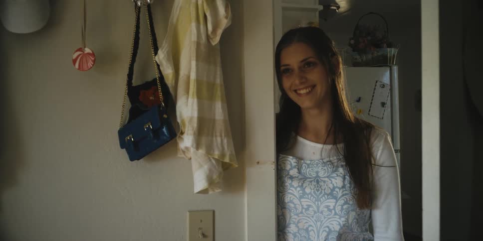 A woman stands by the doorway laughing