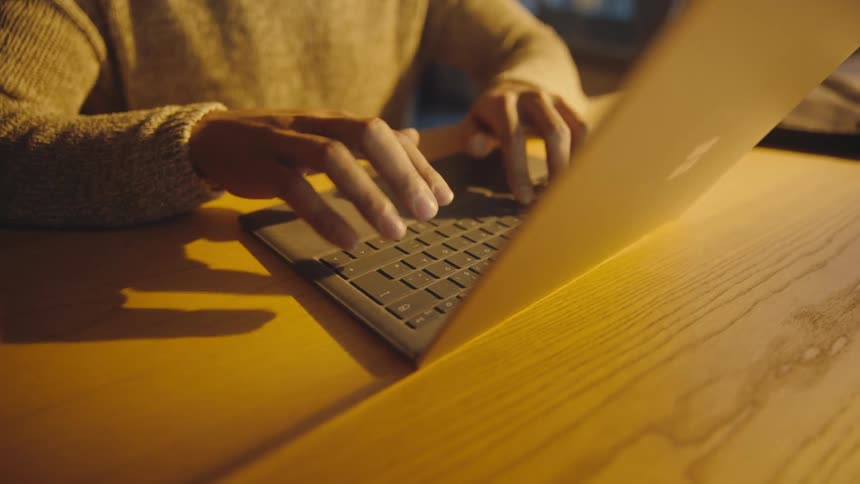 quick camera move of man typing on laptop