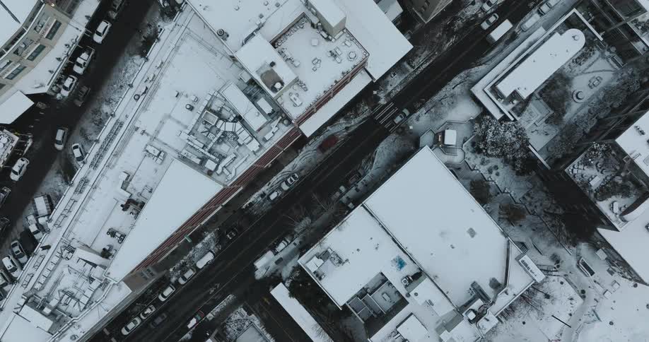 Top down traverse over snow covered buildings and city streets