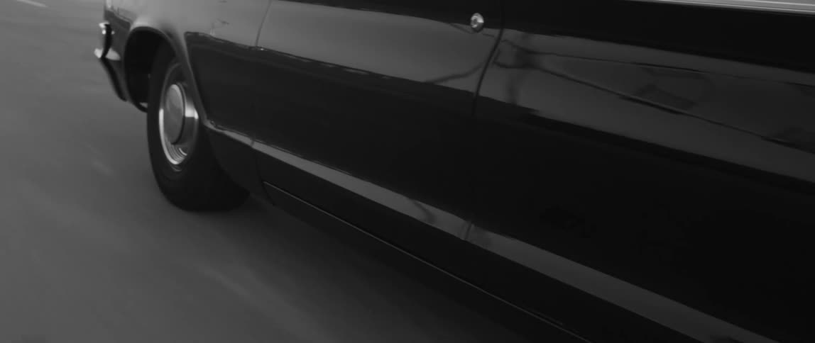 Large vintage car moves along asphalt road