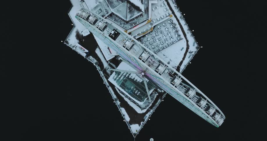 Birds eye view of a spinning Ferris wheel covered in snow