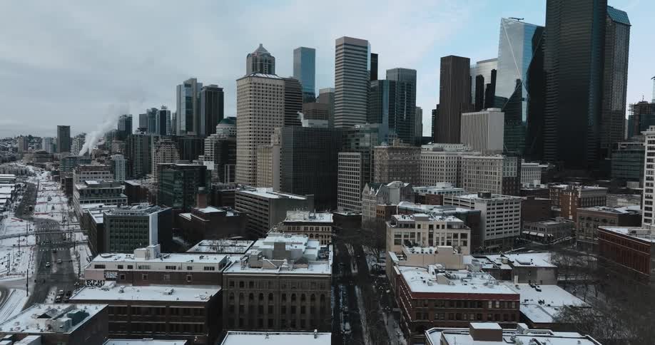 Reveal of a downtown skyline above snowy streets and various low rise buildings