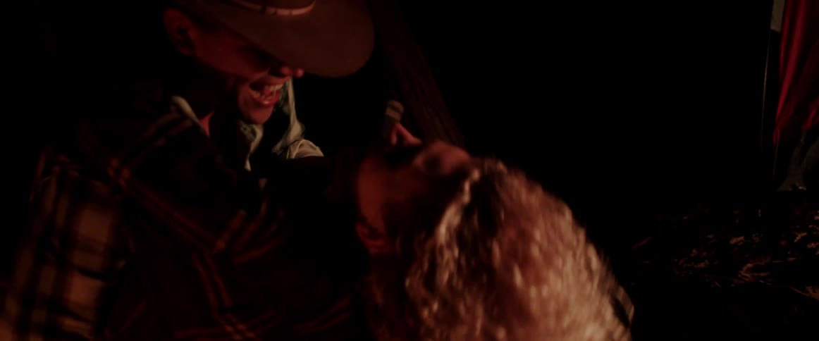 A couple dances by the light of a campfire outdoors at night