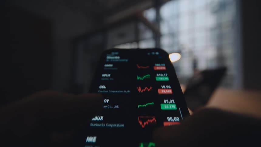 pov close up of smartphone screen while person is scrolling through stock market data 2