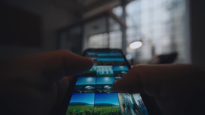 pov close up of smartphone screen while person is scrolling through image photo library