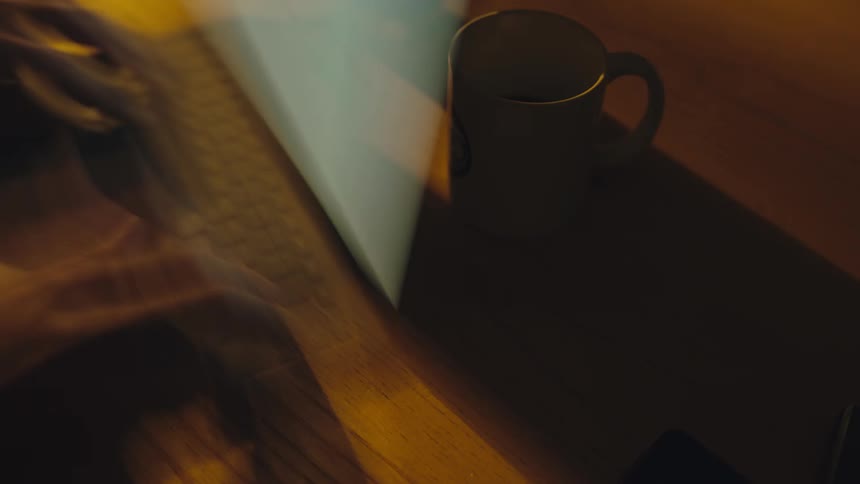 time lapse of a desk and person frantically working from home at night