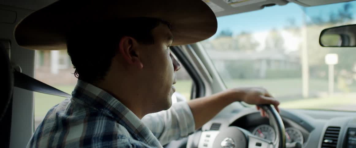 A man talks to his wife while driving through a neighborhood