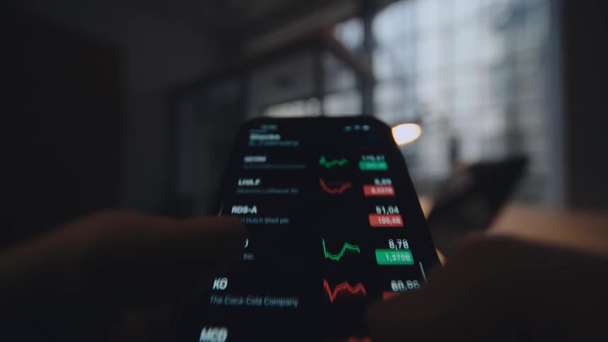 pov close up of smartphone screen while person is scrolling through stock market data