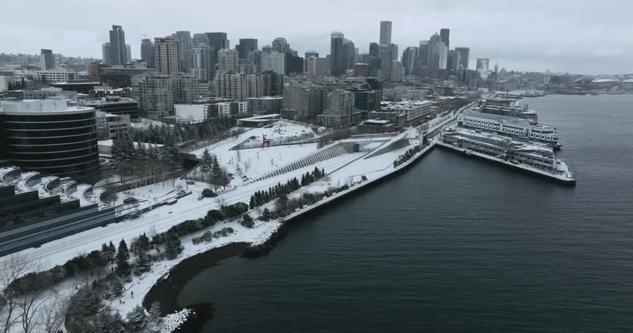 Tilt up reveal of a snow covered city waterfront on a cloudy winter day